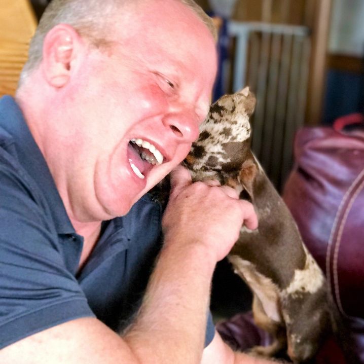 Animal Kingdom owner Frank Mineo Jr. plays with a mommy Dachshund.